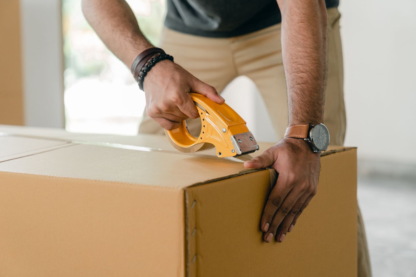 Sealing a cardboard moving box with tape