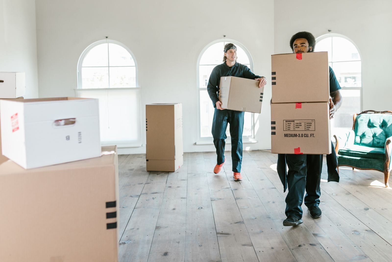 Movers carrying labelled cardboard boxes